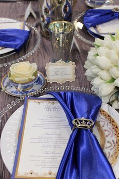 royal blue napkin with crown shaped napkin ring on a table setting