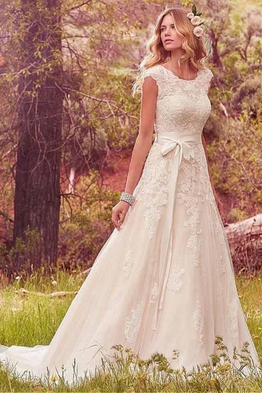 woman walking through woods in wedding gown