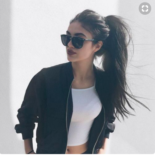 Beautiful girl with long brown ponytail wearing sunglasses.