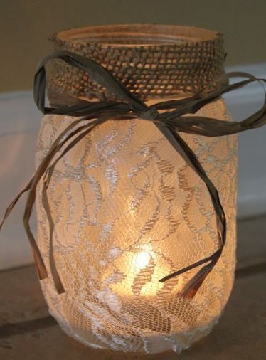 mason jar lined with lace with lit candle inside