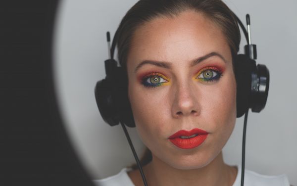 A beauty blogger wears headphones while recording a video.